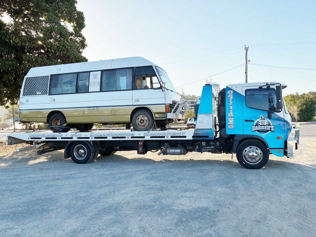 Darren’s Towing tow truck towing a cruiser van in Townsville.