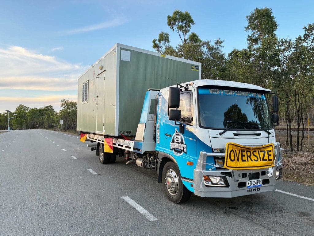 Darren’s Towing hauling an oversize load — a portable building in Townsville.