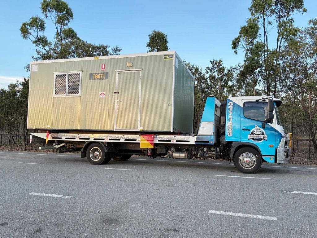 Darren’s Towing hauling an oversize load — a portable building in Townsville.