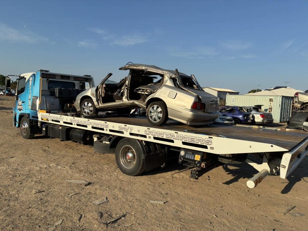 Car body removal service by Darren’s Towing in Townsville — vehicle being hauled away for scrap metal.
